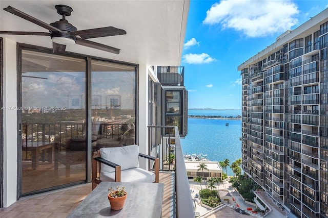 balcony with a water view and ceiling fan