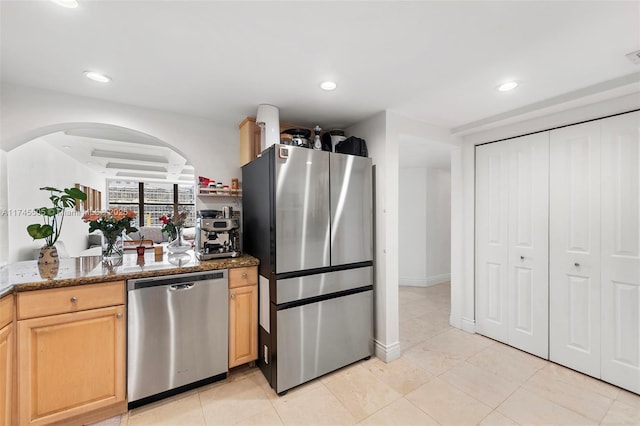 1915 Brickell Ave Unit C1612, Miami, FL 33129 - kitchen featuring stainless steel appliances, arched walkways, light brown cabinets, recessed lighting, and dark stone counters