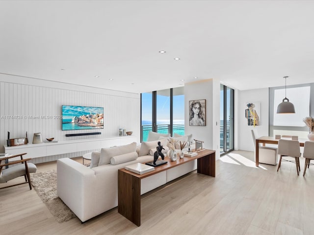 living room featuring light wood-type flooring, floor to ceiling windows, and recessed lighting