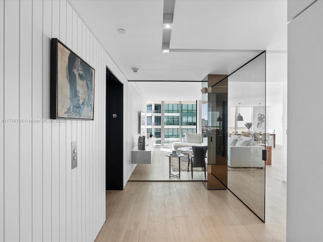 hall featuring light wood-type flooring and expansive windows