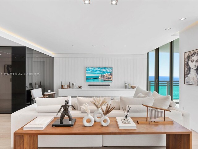 living room with light wood-style floors, expansive windows, and recessed lighting
