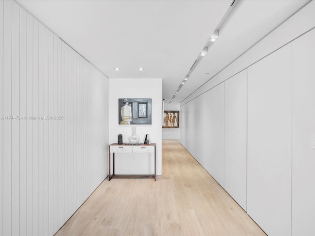 hall with track lighting and light wood finished floors