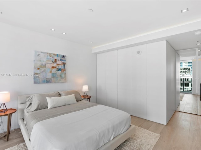 bedroom with light wood-style floors and recessed lighting