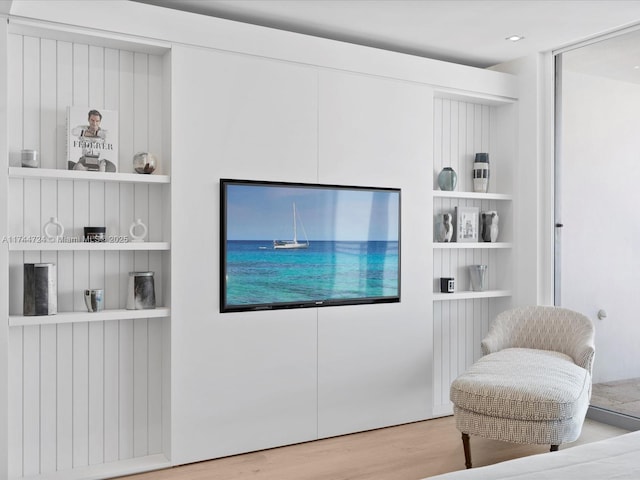 living area featuring built in shelves and wood finished floors