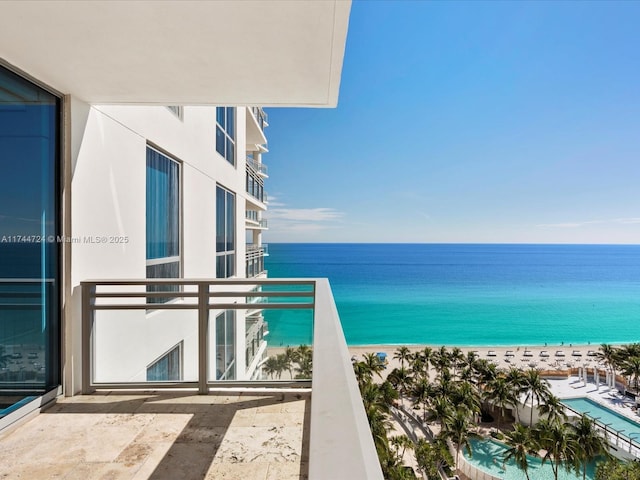 balcony with a water view and a beach view