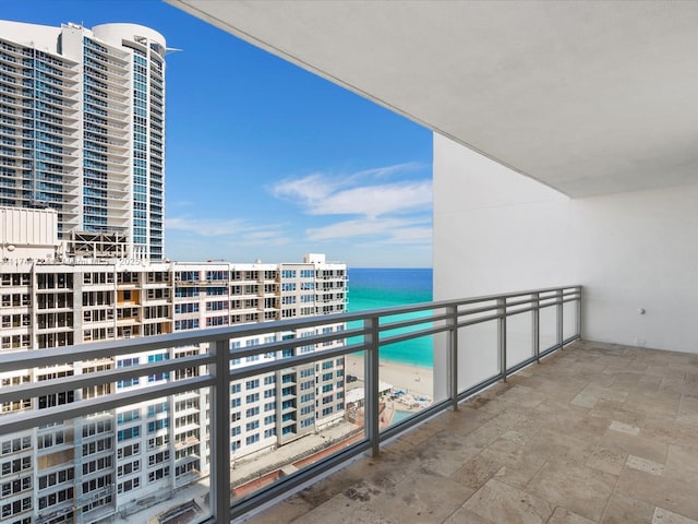 balcony featuring a beach view and a water view