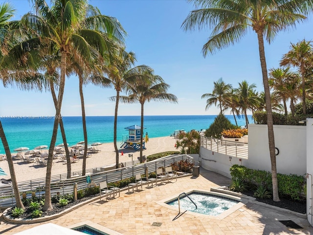 property view of water with fence and a view of the beach