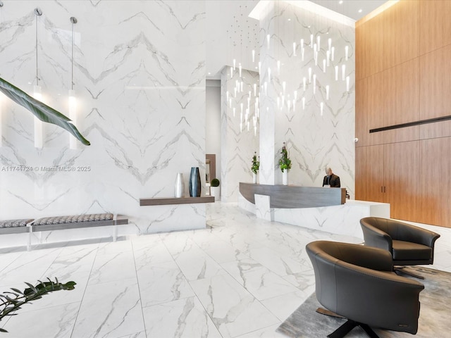 full bath with stone wall, a marble finish shower, and marble finish floor