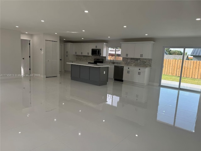 kitchen featuring dishwasher, electric range, white cabinets, a kitchen island, and decorative backsplash