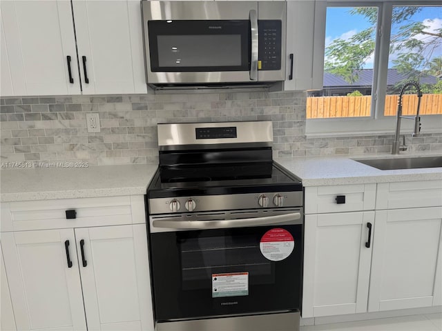 kitchen featuring white cabinetry, stainless steel appliances, sink, and decorative backsplash