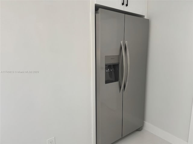 interior details with stainless steel fridge and white cabinets