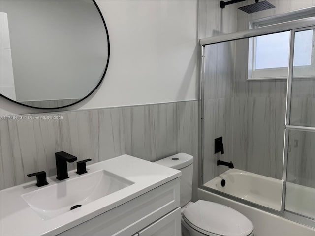 full bathroom featuring vanity, toilet, and combined bath / shower with glass door