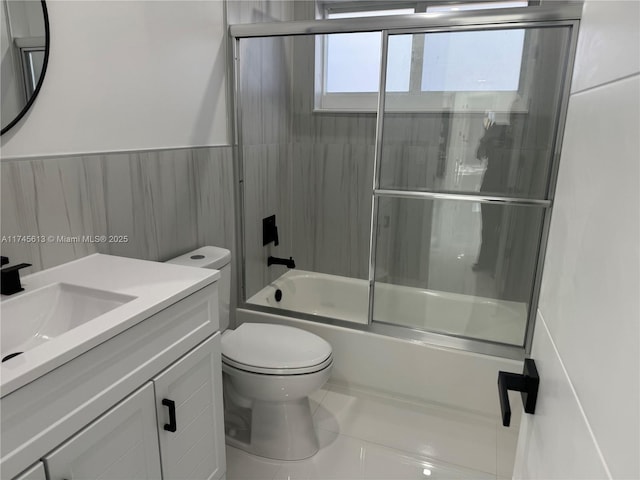 full bathroom with tile patterned floors, vanity, toilet, and combined bath / shower with glass door