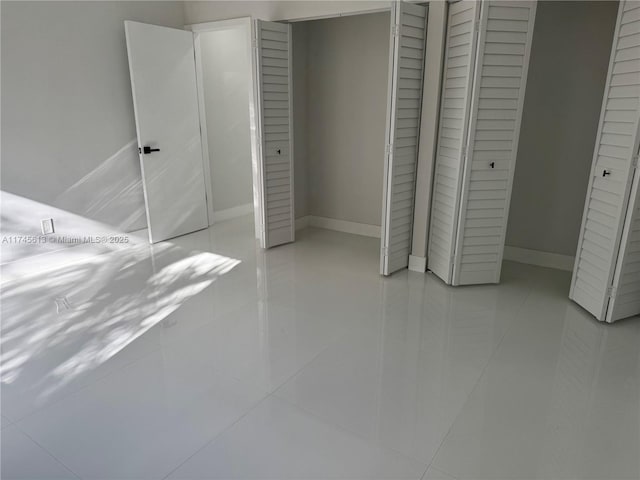 unfurnished bedroom with light tile patterned floors and a closet