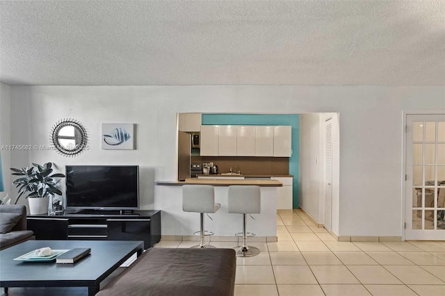 living room with light tile patterned flooring and a textured ceiling