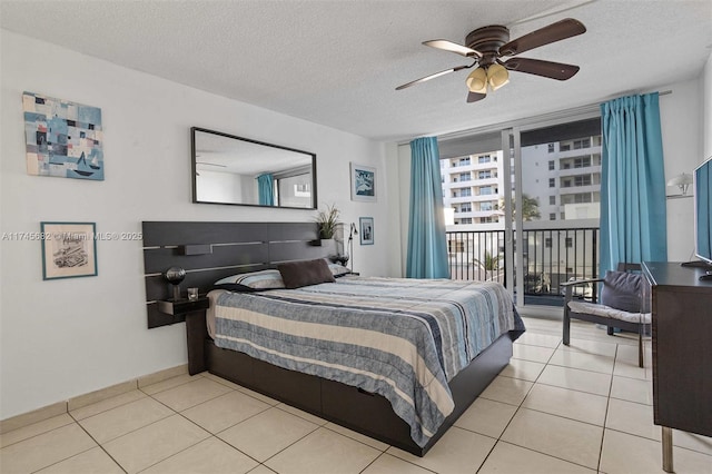 tiled bedroom with access to exterior, a wall of windows, a textured ceiling, and ceiling fan