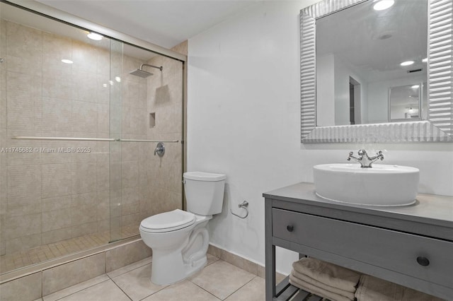 bathroom featuring tile patterned flooring, vanity, a shower with shower door, and toilet