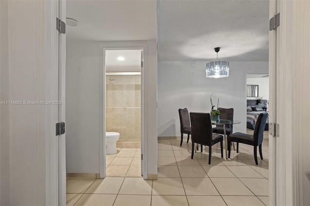 tiled dining room featuring a textured ceiling