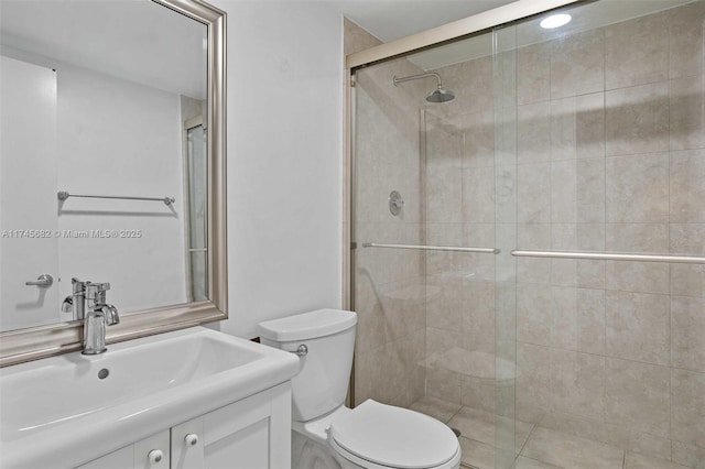 bathroom featuring vanity, toilet, and a shower with shower door