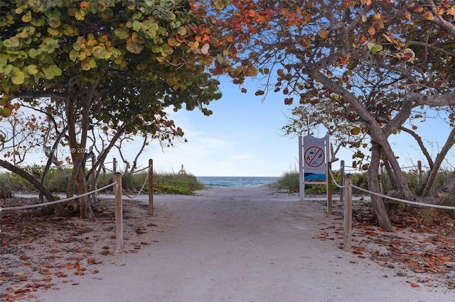 view of home's community featuring a water view and a beach view