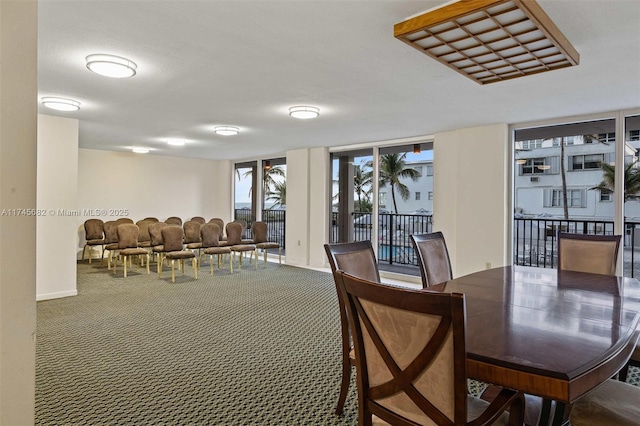 carpeted dining room with a wall of windows