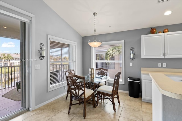 tiled dining space with vaulted ceiling