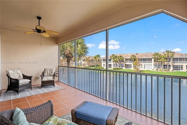 sunroom with vaulted ceiling, a water view, and ceiling fan