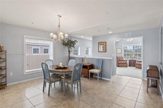 tiled dining area featuring an inviting chandelier