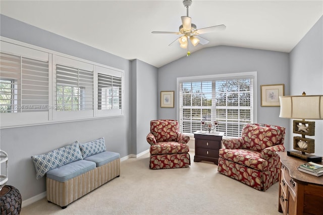 living area featuring a wealth of natural light, lofted ceiling, light colored carpet, and ceiling fan