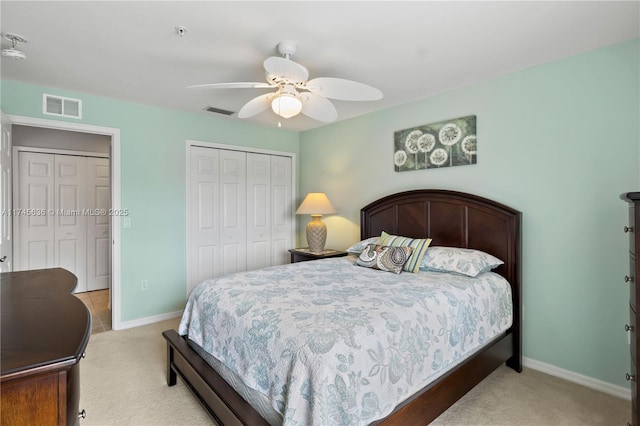 bedroom with light carpet, ceiling fan, and a closet