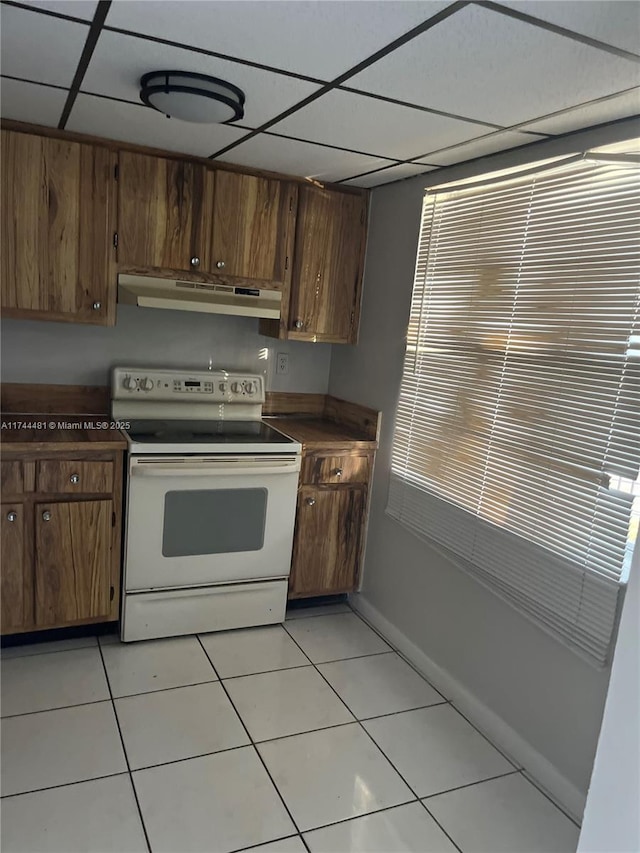 kitchen featuring light tile patterned flooring, a paneled ceiling, and white electric range oven