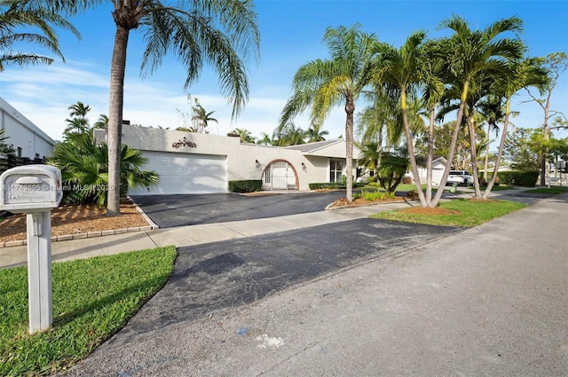 view of front facade with a garage, driveway, and stucco siding