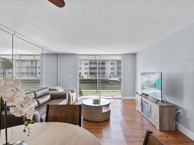 living room with wood finished floors, a textured ceiling, and plenty of natural light