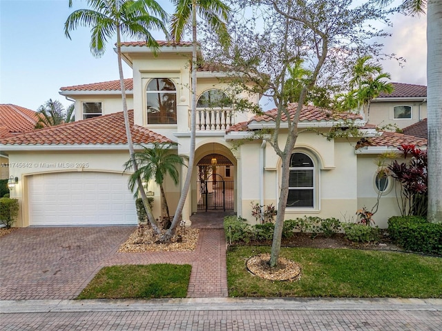 mediterranean / spanish-style house with a garage and a balcony