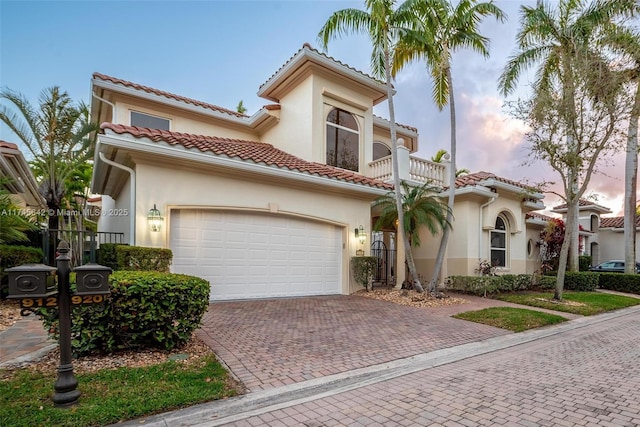 mediterranean / spanish-style house featuring a balcony and a garage