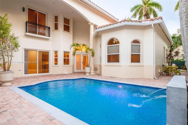 back of house featuring a balcony and a patio area