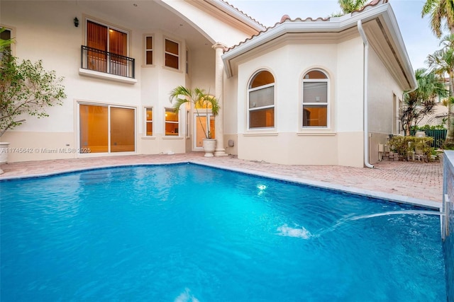 rear view of house featuring a patio and a balcony