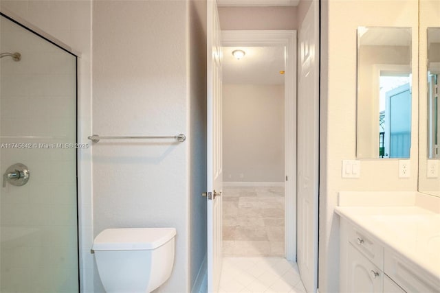 bathroom with vanity, a tile shower, and toilet