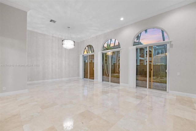 empty room featuring crown molding and an inviting chandelier