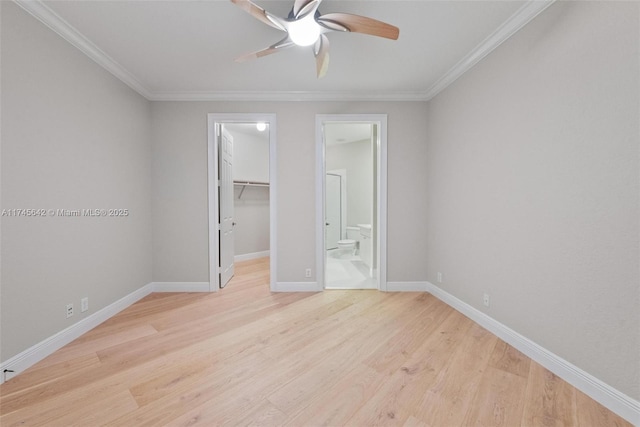 unfurnished bedroom with a spacious closet, ornamental molding, light hardwood / wood-style floors, and a closet