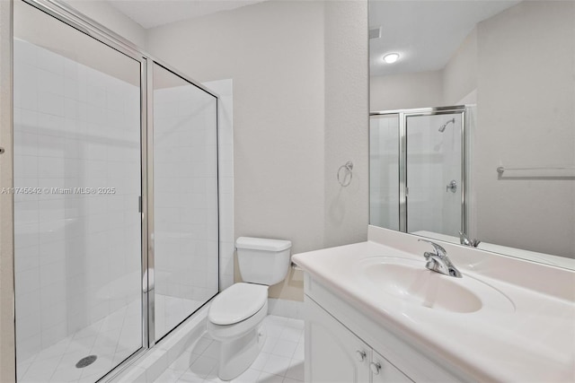 bathroom featuring a shower with door, vanity, tile patterned floors, and toilet