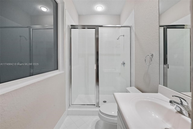 bathroom with tile patterned flooring, an enclosed shower, vanity, a textured ceiling, and toilet