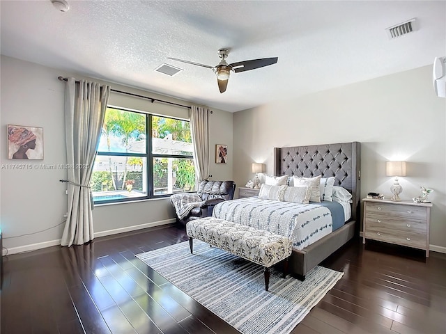 bedroom featuring ceiling fan, dark hardwood / wood-style flooring, and a textured ceiling