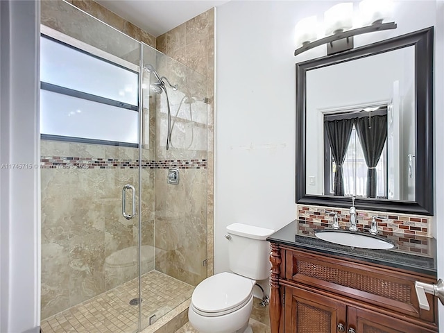 bathroom featuring vanity, toilet, an enclosed shower, and backsplash