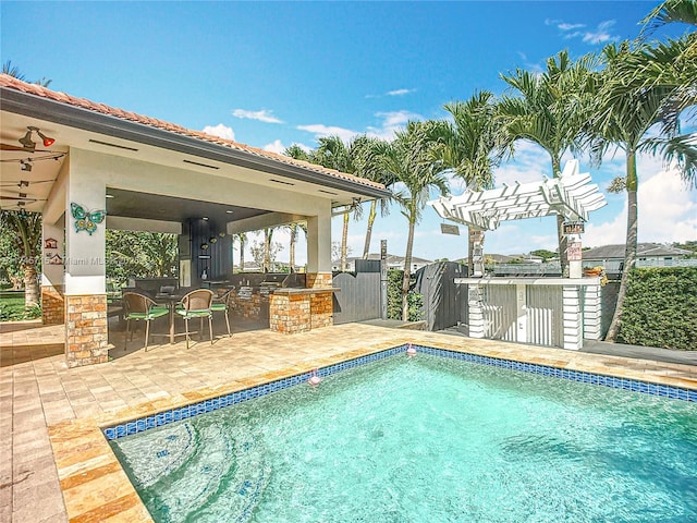 view of swimming pool featuring a bar, a pergola, and a patio