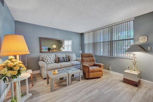 living room featuring light hardwood / wood-style floors and a textured ceiling