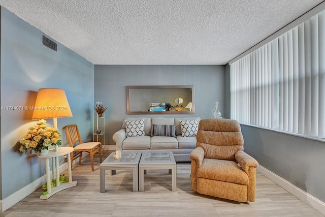 sitting room with light hardwood / wood-style floors and a textured ceiling