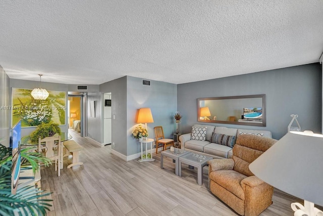 living room with light hardwood / wood-style floors and a textured ceiling