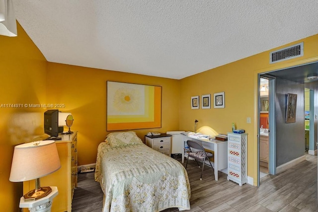 bedroom featuring hardwood / wood-style floors and a textured ceiling