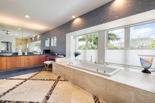 bathroom with vanity, a garden tub, recessed lighting, and a wealth of natural light